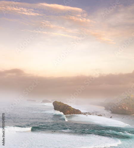 Fotografie A breathtaking panorama of a secluded beach, shrouded in mist and bathed in golden light