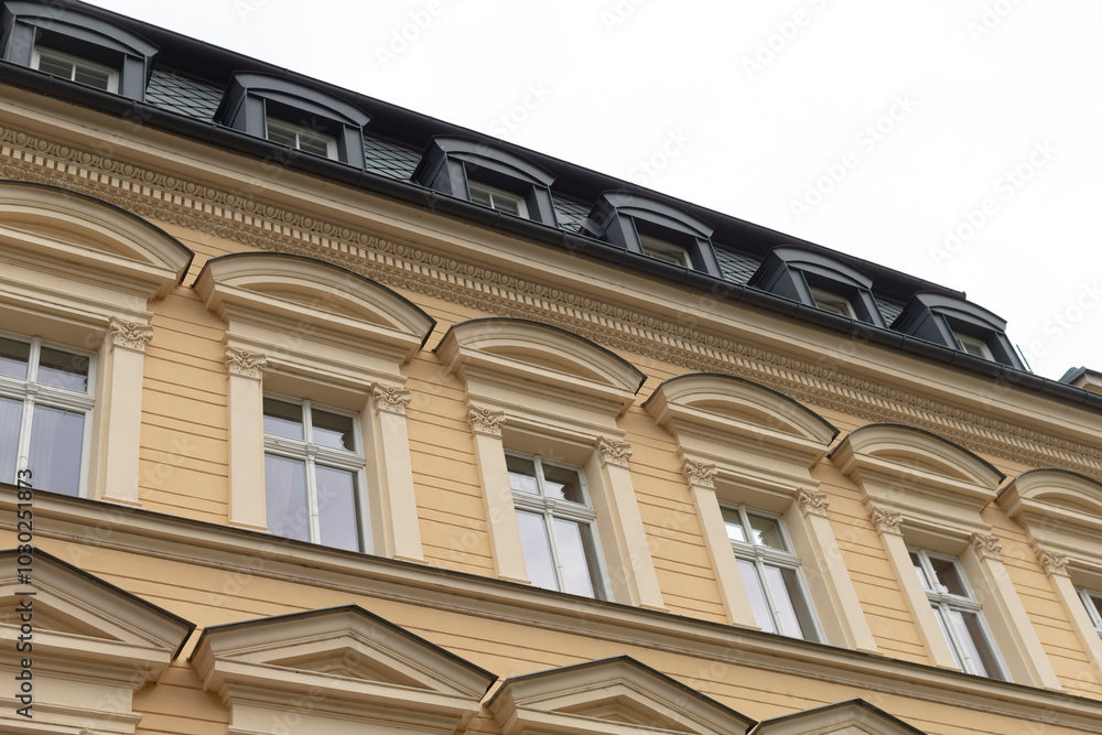 Obraz premium The structure is a large building that features a significant number of windows and has a sleek black roof that stands out
