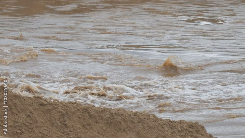 The fast flow of dirty water. Dirty water is bubbling and flowing