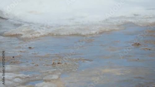 A man slipped on ice. A worker in special clothing walks on a slippery road