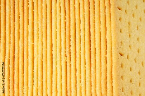 Rectangular, savory salty cheese-flavored biscuits with a golden-yellow color, neatly stacked. Perfect as a snack. Photographed on a white background.
