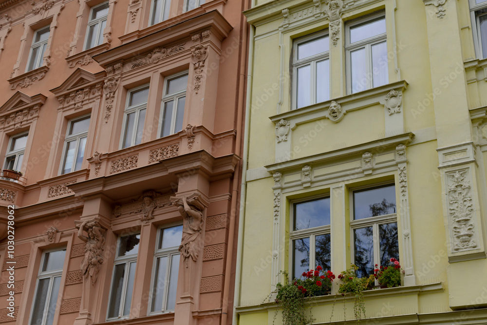 Fototapeta premium Two charming buildings, adorned with vibrant flowers in their windows, stand elegantly next to each other in this lovely neighborhood
