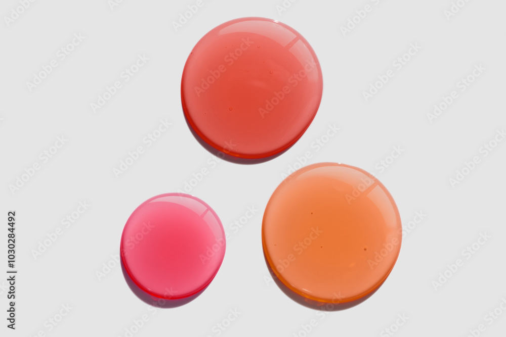 Lip oil or lip gloss pink fuchsia red circle drops texture swatch on gray background Lip oil or lip gloss pink fuchsia red circle drops texture swatch on gray background