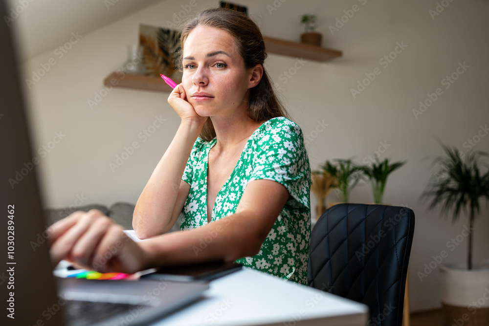 Adult brunette woman sitting at the desk and using her laptop, adult female student watching online educational video courses. Adult brunette woman sitting at the desk and using her laptop, adult female student watching online educational video courses.