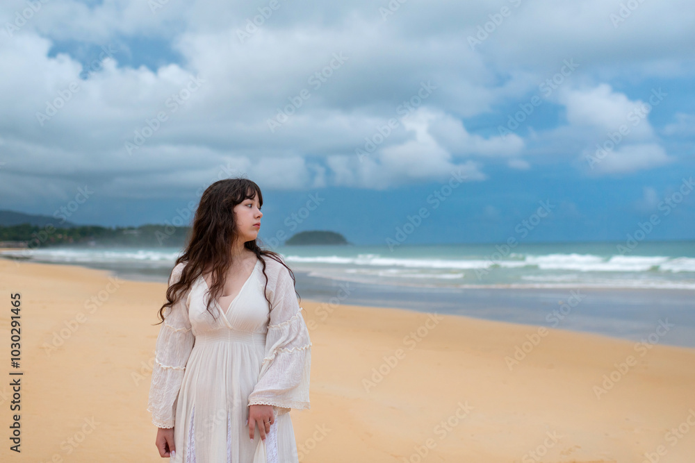 Portrait of young traveller woman in white dress and hat standing on beautiful sandy beach. Cute girl enjoy her tropical sea on relax holiday vacation during summer time and sunshine day Portrait of young traveller woman in white dress and hat standing on beautiful sandy beach. Cute girl enjoy her tropical sea on relax holiday vacation during summer time and sunshine day