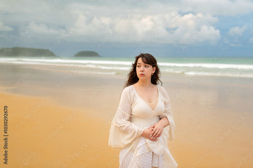 Portrait of young traveller woman in white dress and hat standing on beautiful sandy beach. Cute girl enjoy her tropical sea on relax holiday vacation during summer time and sunshine day Portrait of young traveller woman in white dress and hat standing on beautiful sandy beach. Cute girl enjoy her tropical sea on relax holiday vacation during summer time and sunshine day