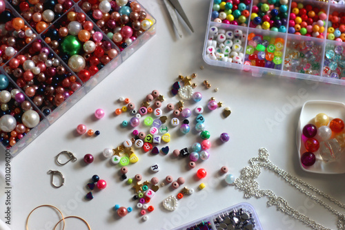 Obraz na płótnie Colorful beads, letter beads, threads and other jewelry making supplies on white background. Making friendship bracelets concept. Selective focus. w salonie