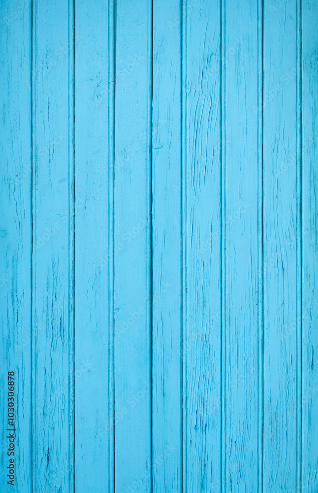 A vertical photograph of old boards tinted blue with an expressive texture. The paint has peeled off in places due to time and bad weather. A vertical photograph of old boards tinted blue with an expressive texture. The paint has peeled off in places due to time and bad weather.