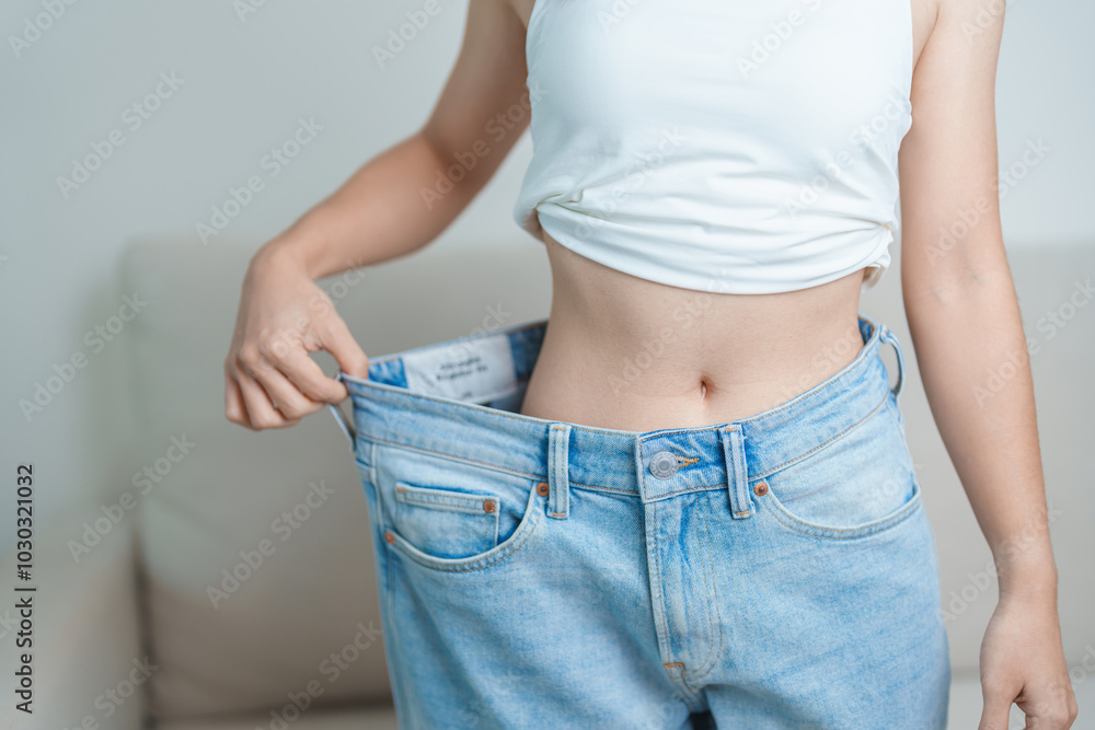 Φωτογραφία young slim female wearing big or oversize jeans, woman show healthy shape after weight loss