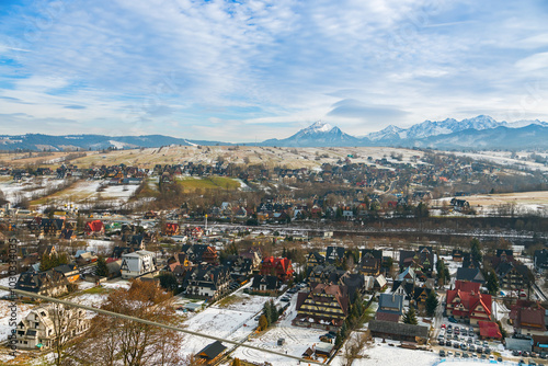 A view of Zakopane, Poland, with a road leading into a valley filled with alpine-style homes