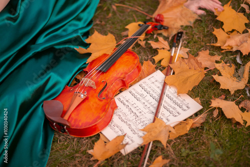 girl holding treble clef and violin on autumn leaves