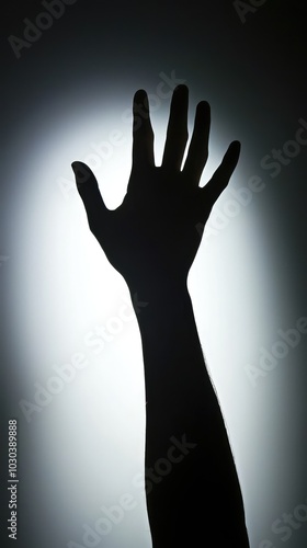 Silhouette of a Hand Reaching Toward Light