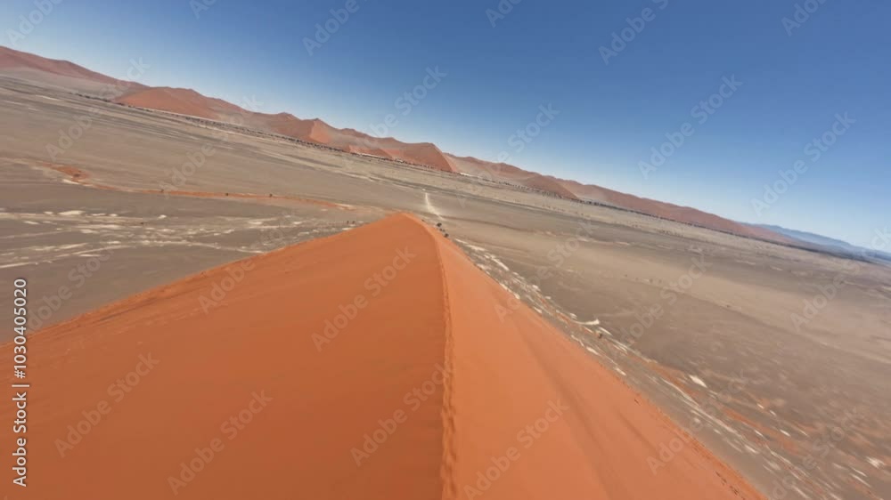 Aerial view with FPV drone going fast down the ridge of the giant dune of Duna 45 on a beautiful sunny day in Sossusvlei, Namibia, Africa Aerial view with FPV drone going fast down the ridge of the giant dune of Duna 45 on a beautiful sunny day in Sossusvlei, Namibia, Africa