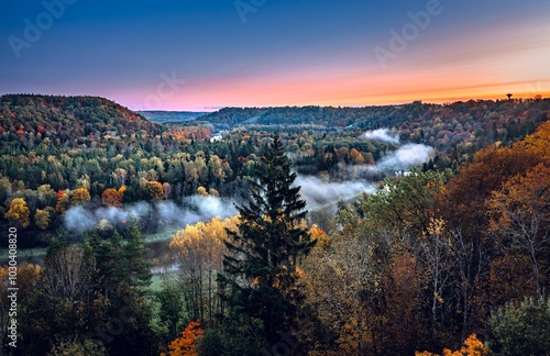 Obraz na płótnie Colorful sunrise over the Gauja National park valley. Sigulda city panorama from drone with forest in autumn colors. w salonie