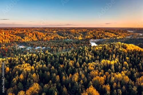 Obraz na płótnie Colorful sunrise over the Gauja National park valley. Sigulda city panorama from drone with forest in autumn colors. w salonie