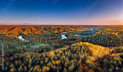 Obraz na płótnie Colorful sunrise over the Gauja National park valley. Sigulda city panorama from drone with forest in autumn colors. w salonie