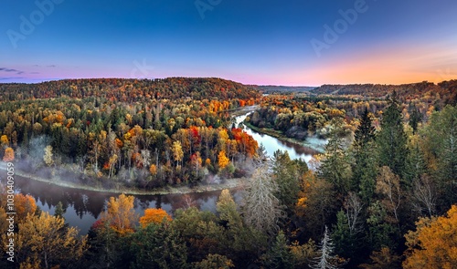 Obraz na płótnie Colorful sunrise over the Gauja National park valley. Sigulda city panorama from drone with forest in autumn colors. w salonie
