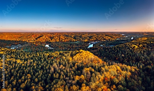 Obraz na płótnie Colorful sunrise over the Gauja National park valley. Sigulda city panorama from drone with forest in autumn colors. w salonie