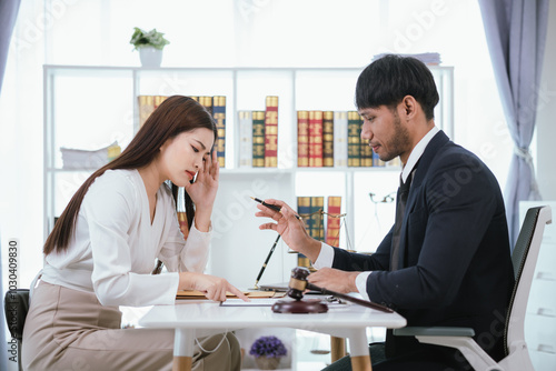 Confident businesswoman sitting at desk reviewing legal documents and contracts to ensure fairness and balanced decisions in legal and criminal matters.