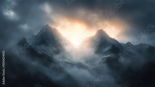 Misty mountains at dawn with sunrays breaking through the clouds