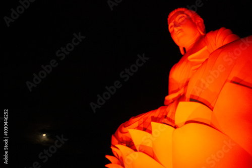 Golden Buddha Statue in Vibrant Orange Glow photo