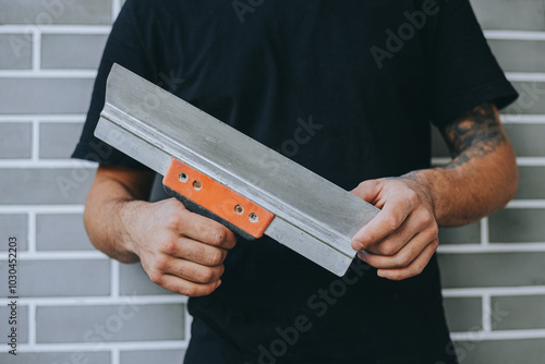 Close-Up of Spatula in Man's Hand for Wall Work photo