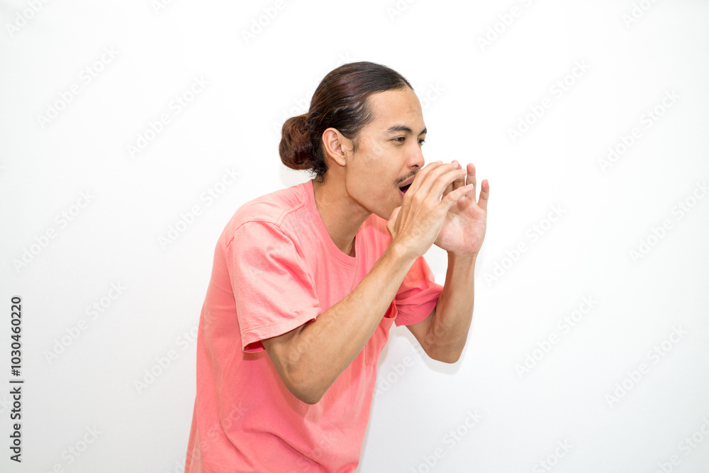 An Indonesian, Asian man wearing a pink tshirt shows a fierce expression as if he is angry or frustrated. isolated in white background An Indonesian, Asian man wearing a pink tshirt shows a fierce expression as if he is angry or frustrated. isolated in white background
