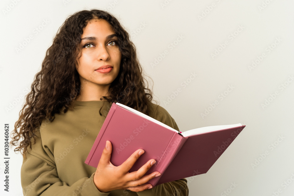 Girl in gray with book on the . female person education concept. a girl standing on a gray with an open book in her hands. a girl in gray stands on a white wall with an open book in hands her. Girl in gray with book on the . female person education concept. a girl standing on a gray with an open book in her hands. a girl in gray stands on a white wall with an open book in hands her.
