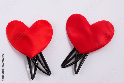 Heart with hairpins on gray. fashion female gift concept. a colorful heart shaped hairpin on a gray . a cute little girl with heart shaped hairpins on a lifestyle gray. photo