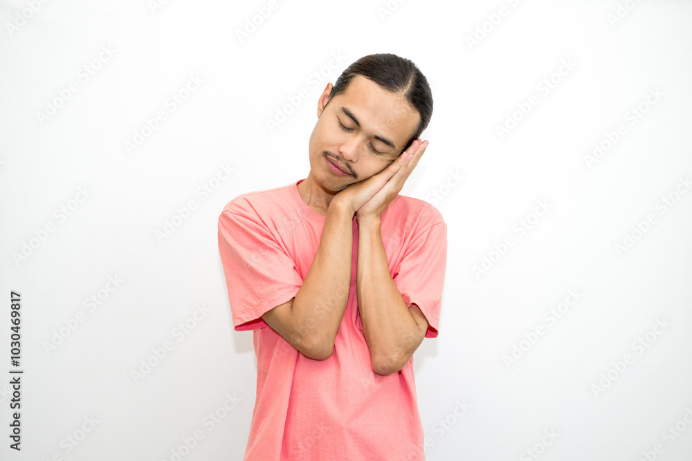 Asian, Indonesian man with long hair and bored face, sleepy and yawning standing wearing pink shirt. isolated on white background Asian, Indonesian man with long hair and bored face, sleepy and yawning standing wearing pink shirt. isolated on white background