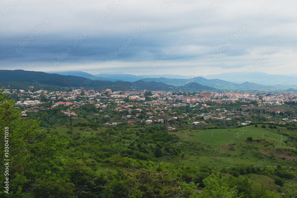 Aerial view of the lush landscape and urban area of Nagorno Karabakh under cloudy skies during the late afternoon Aerial view of the lush landscape and urban area of Nagorno Karabakh under cloudy skies during the late afternoon