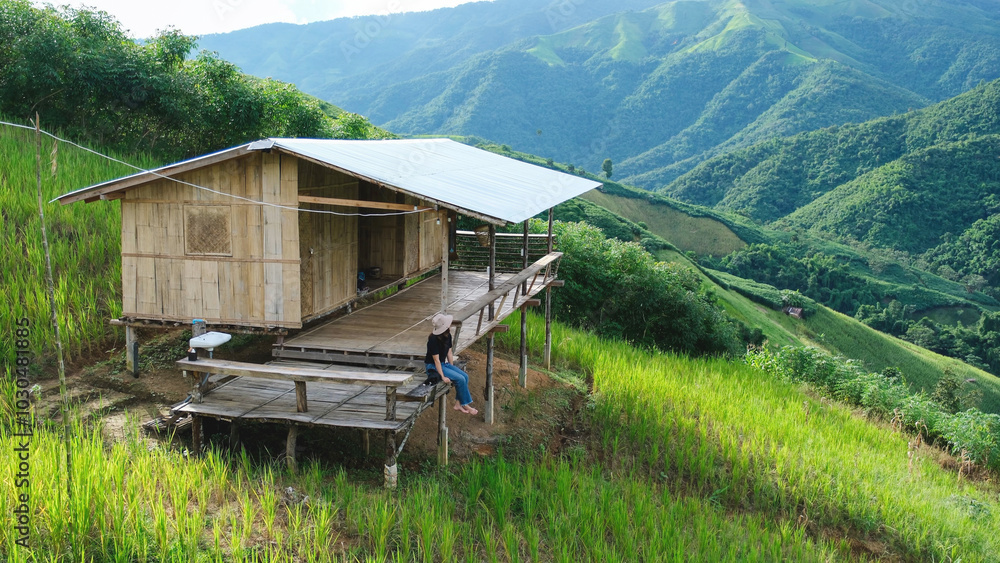 A woman sitting in wooden cabin and looking at a mountain view A woman sitting in wooden cabin and looking at a mountain view