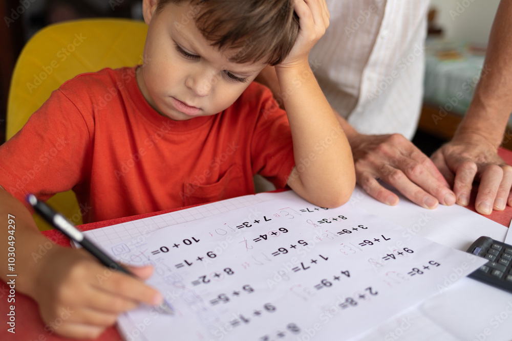 A boy with dyscalculia and dysgraphia tries to complete his math homework. A boy with dyscalculia and dysgraphia tries to complete his math homework.