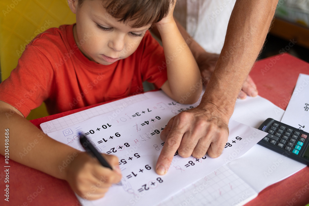 A boy with dyscalculia and dysgraphia tries to complete his math homework. A boy with dyscalculia and dysgraphia tries to complete his math homework.