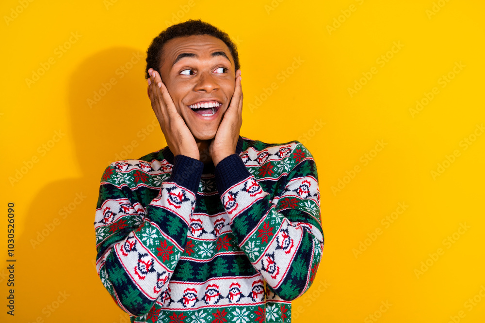 Photo of funky young guy look amazed empty space dressed ornament christmas garment celebrate winter holidays on yellow background Photo of funky young guy look amazed empty space dressed ornament christmas garment celebrate winter holidays on yellow background