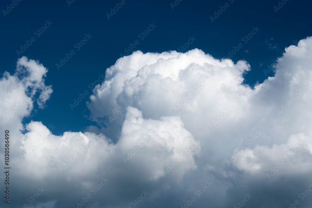 White fluffy cloud against dark blue sky White fluffy cloud against dark blue sky