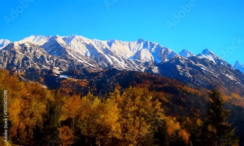 A mountain in the USA in autumn, with scenic snow-covered mountains in the background, tourists travel to enjoy nature and life concepts.