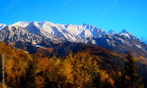 A mountain in the USA in autumn, with scenic snow-covered mountains in the background, tourists travel to enjoy nature and life concepts.