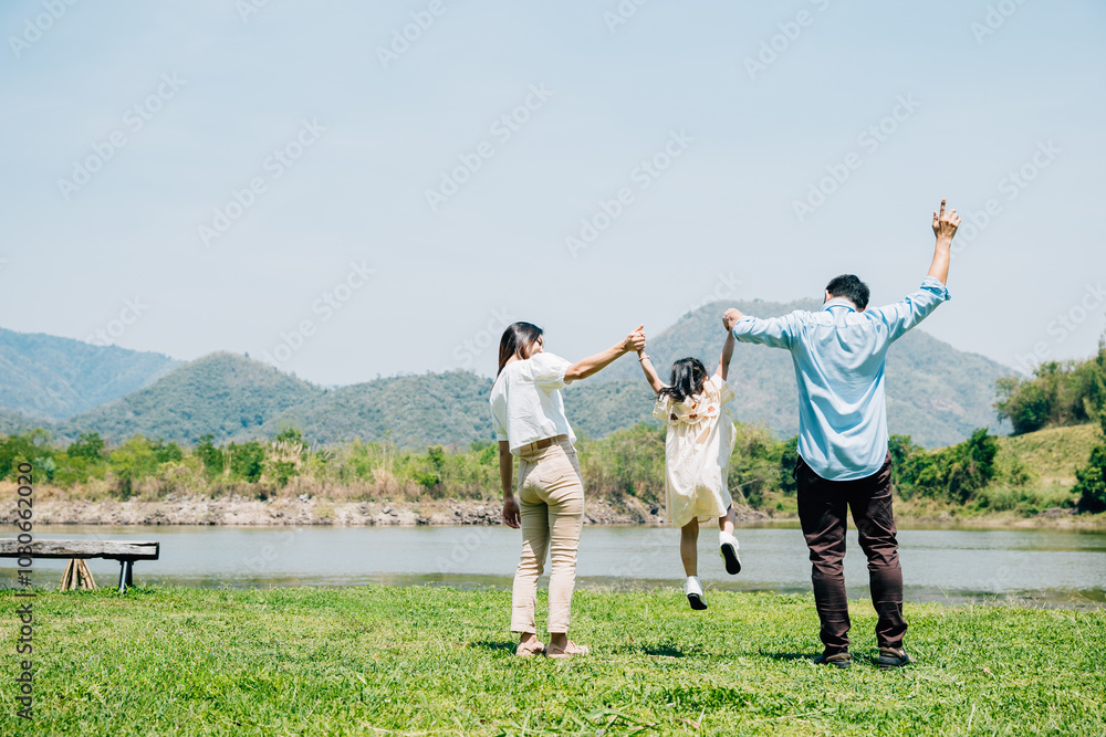 Asian family father mother and daughter jumping front lake with raised hands sunny day in park, lifestyle parents and child kid enjoying outdoors together in nature on summer travel, Family relaxation Asian family father mother and daughter jumping front lake with raised hands sunny day in park, lifestyle parents and child kid enjoying outdoors together in nature on summer travel, Family relaxation