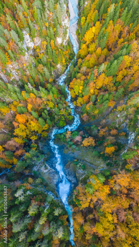 A stunning aerial capture of Martuljek Lower Waterfall in the autumn season, surrounded by vibrant fall foliage in the Slovenian Alps A stunning aerial capture of Martuljek Lower Waterfall in the autumn season, surrounded by vibrant fall foliage in the Slovenian Alps