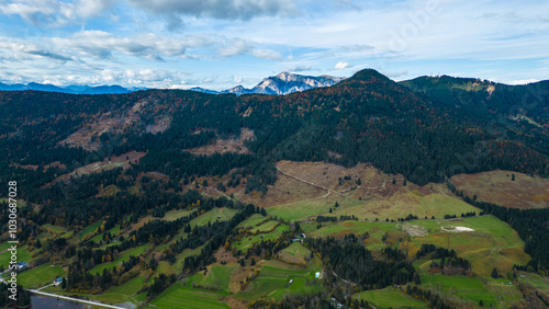 A stunning aerial view of Gozd Martuljek and its surroundings in autumn, captured by drone. The vibrant colors of the fall foliage create a breathtaking contrast against the majestic mountains photo