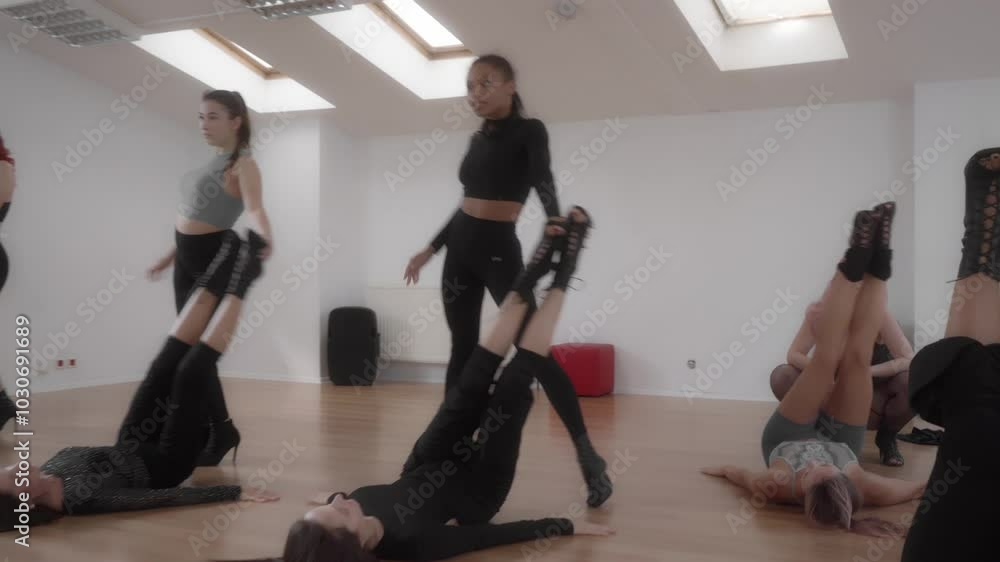 A group of women practices a High Heels routine in a dance studio. The students rehearse expressive dance moves as part of their hobby. Adult dance classes provide a creative and empowering experience A group of women practices a High Heels routine in a dance studio. The students rehearse expressive dance moves as part of their hobby. Adult dance classes provide a creative and empowering experience
