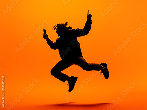 Wallpaper Mural An happy men jumping on an orange background. In a silhouette street fashion outfit.  Torontodigital.ca