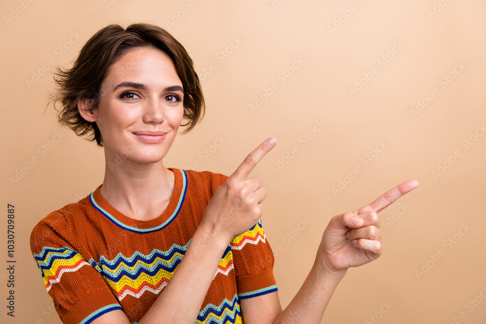 Portrait of gorgeous friendly person indicate fingers empty space ad blank isolated on beige color background Portrait of gorgeous friendly person indicate fingers empty space ad blank isolated on beige color background