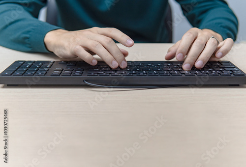 Close up businessman hands using a computer in the office, front view, typing the keyboard, business concept