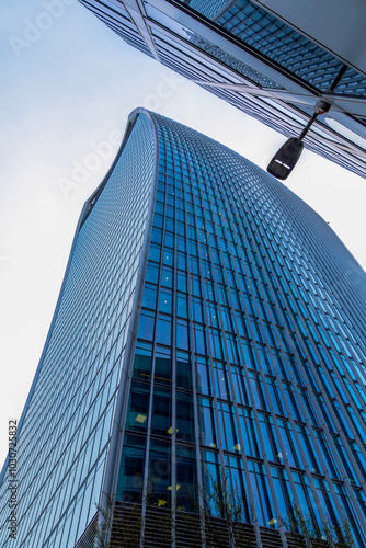 Stunning view from below of the legendary curved skyscraper 20 Fenchurch Street, also known as Walkie-Talkie, with the clear blue sky reflecting in the windows of its facade. photo