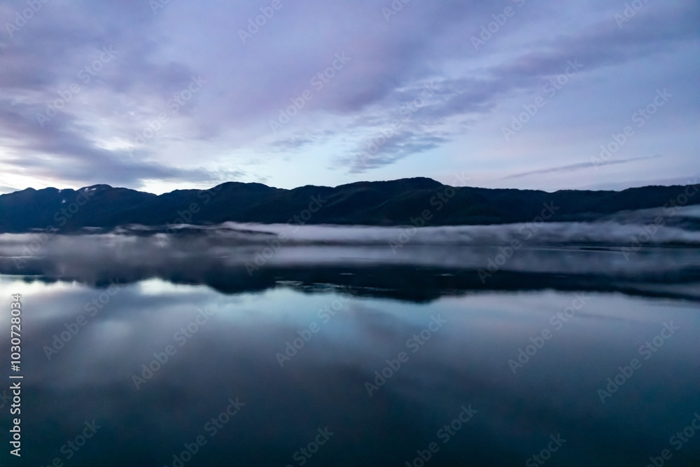 Lilac Skies Cloudscape in Alaska during the fall, cascading over still waters - the calm before the storm. Lilac Skies Cloudscape in Alaska during the fall, cascading over still waters - the calm before the storm.