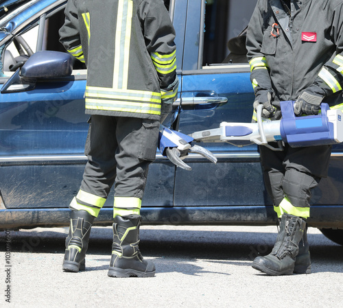 Firefighters use powerful hydraulic shears to rip off the doors of a crashed car photo