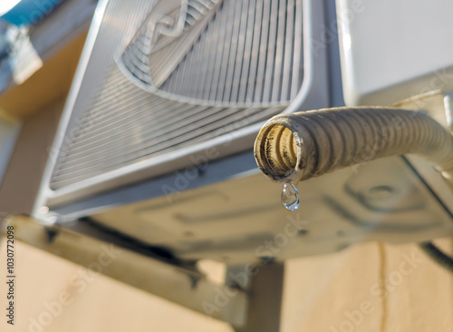 Water dripping from the drain pipe of the outdoor unit of the air conditioner, photo