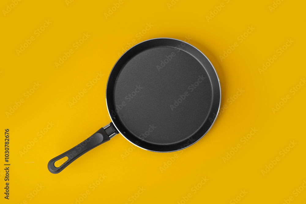 Frying pan with non-stick coating, kitchen equipment tool on yellow background. Frying pan with non-stick coating, kitchen equipment tool on yellow background.
